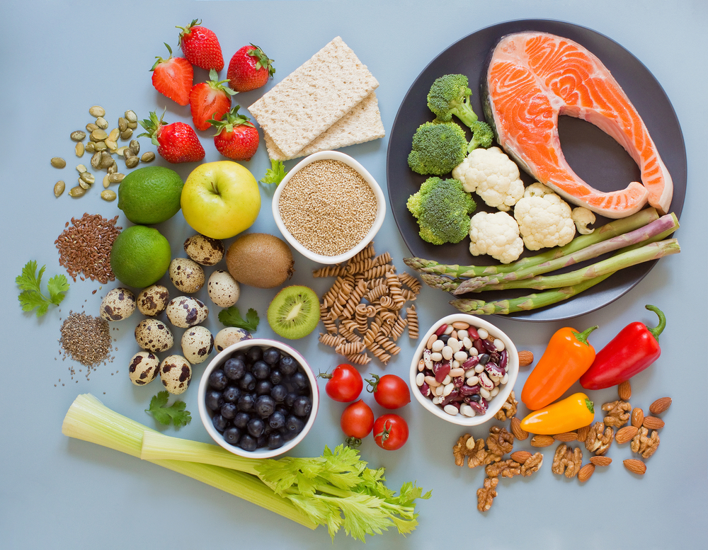 Balanced diet food background. Fresh vegatables, fruits, cereals, seeds and nuts on a blue background